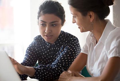 Two women looking at a computer screen together